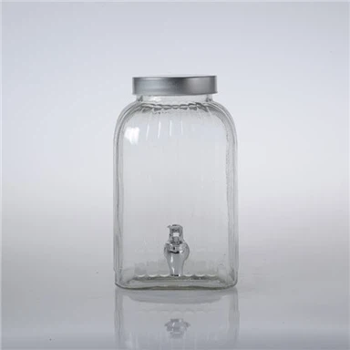 Dispensador de bebidas de vidrio con tapa de hojalata.